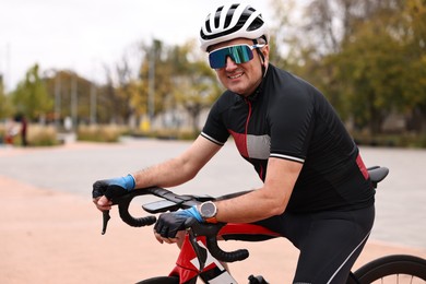 Photo of Athletic man with helmet and bicycle outdoors