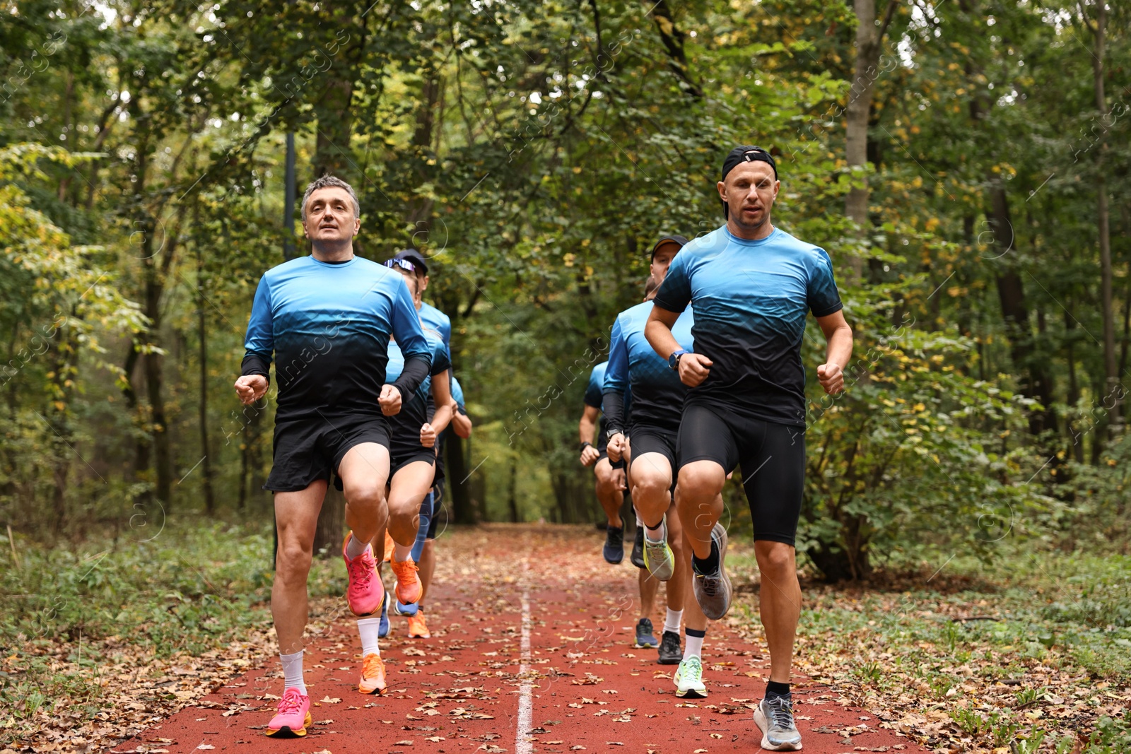 Photo of Group of athletic people running in park