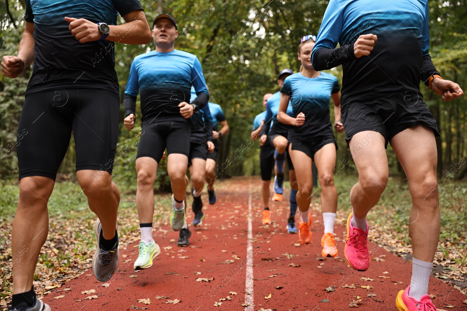 Photo of Group of athletic people running in park