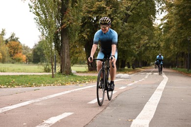 Photo of Group of athletic people riding bicycles outdoors