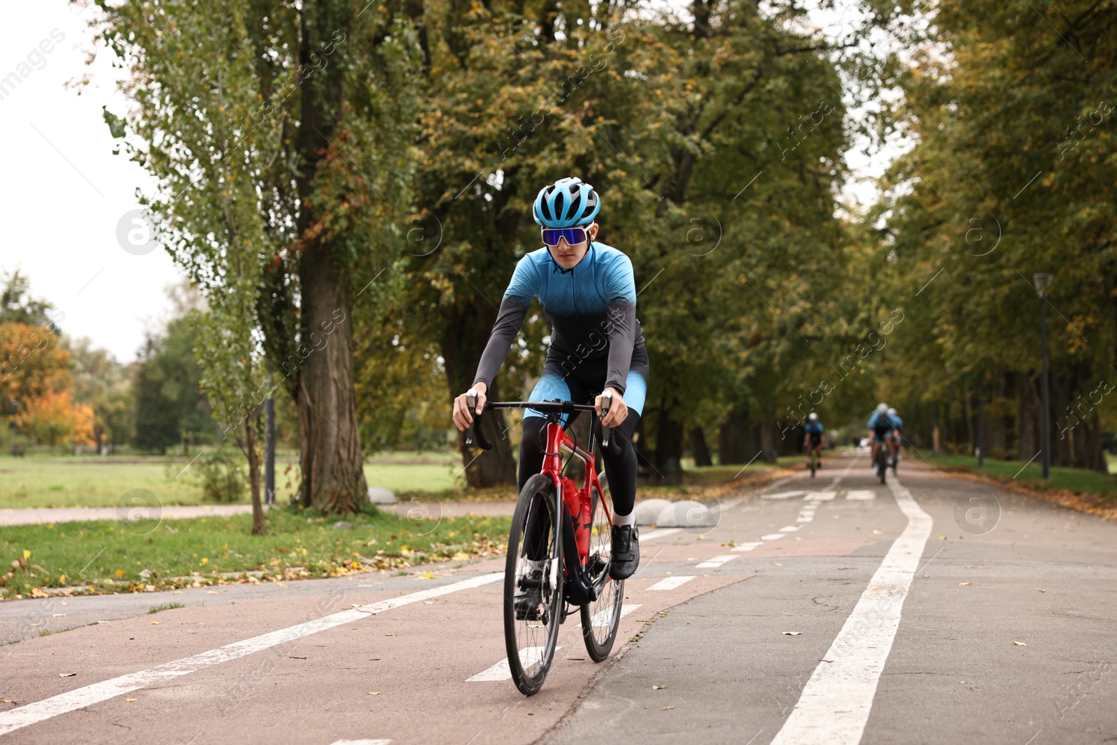 Photo of Athletic man with helmet riding bicycle outdoors