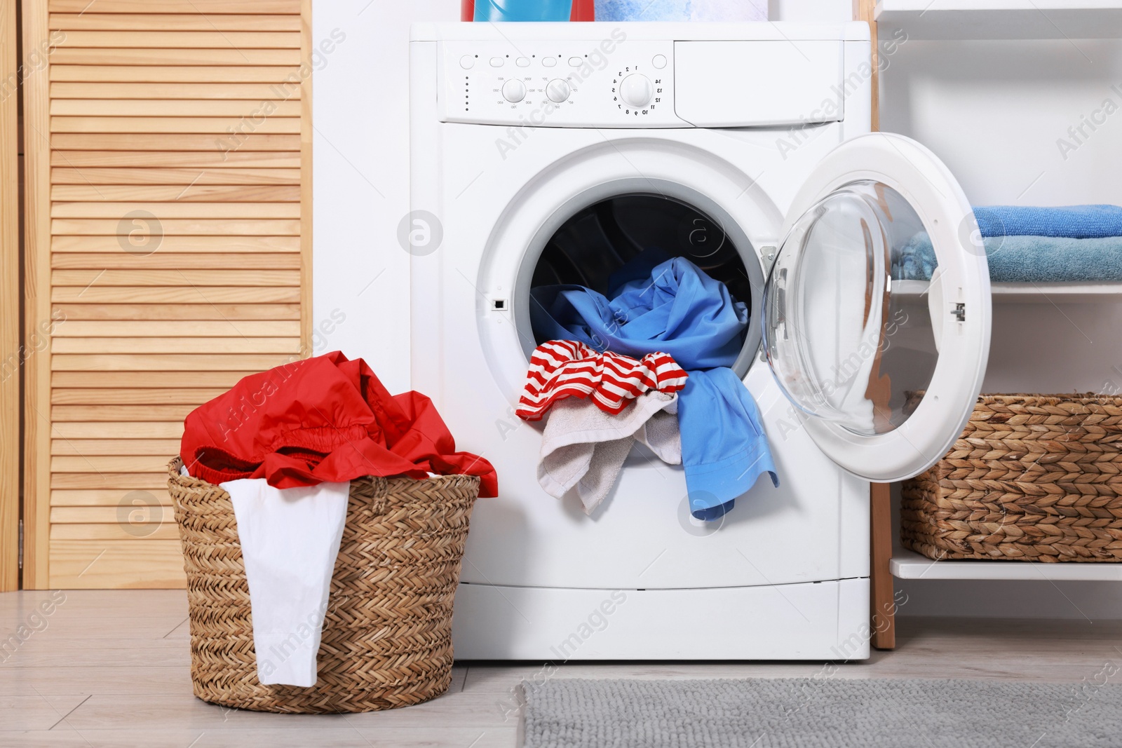 Photo of Washing machine and basket with laundry in room