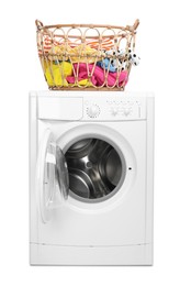 Photo of Washing machine and laundry basket with colorful clothes isolated on white