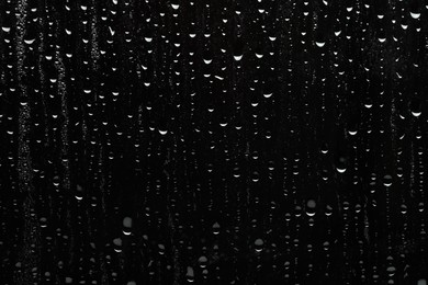 Water drops on black glass surface, top view