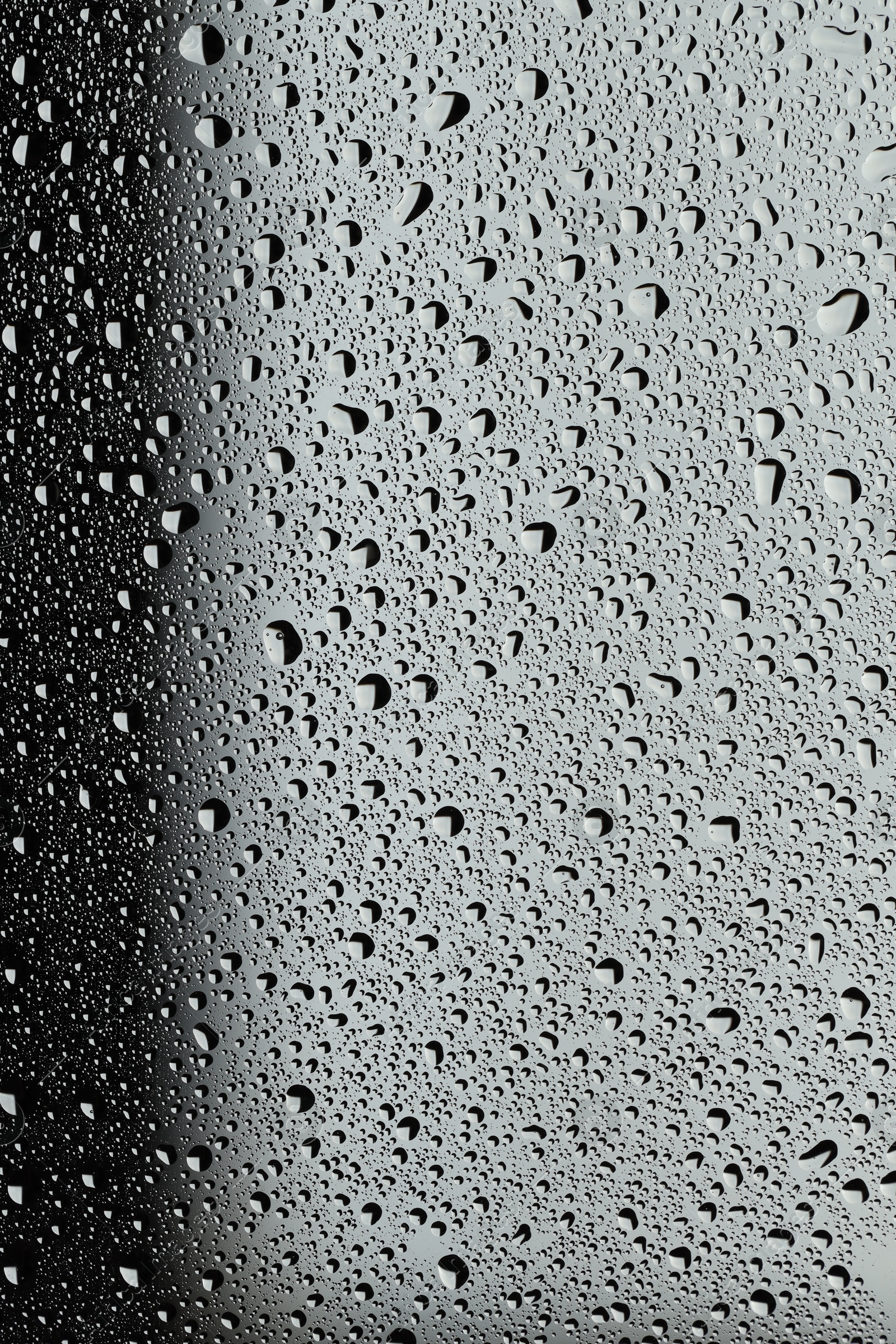 Photo of Water drops on grey glass surface, top view