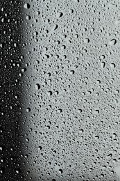 Water drops on grey glass surface, top view