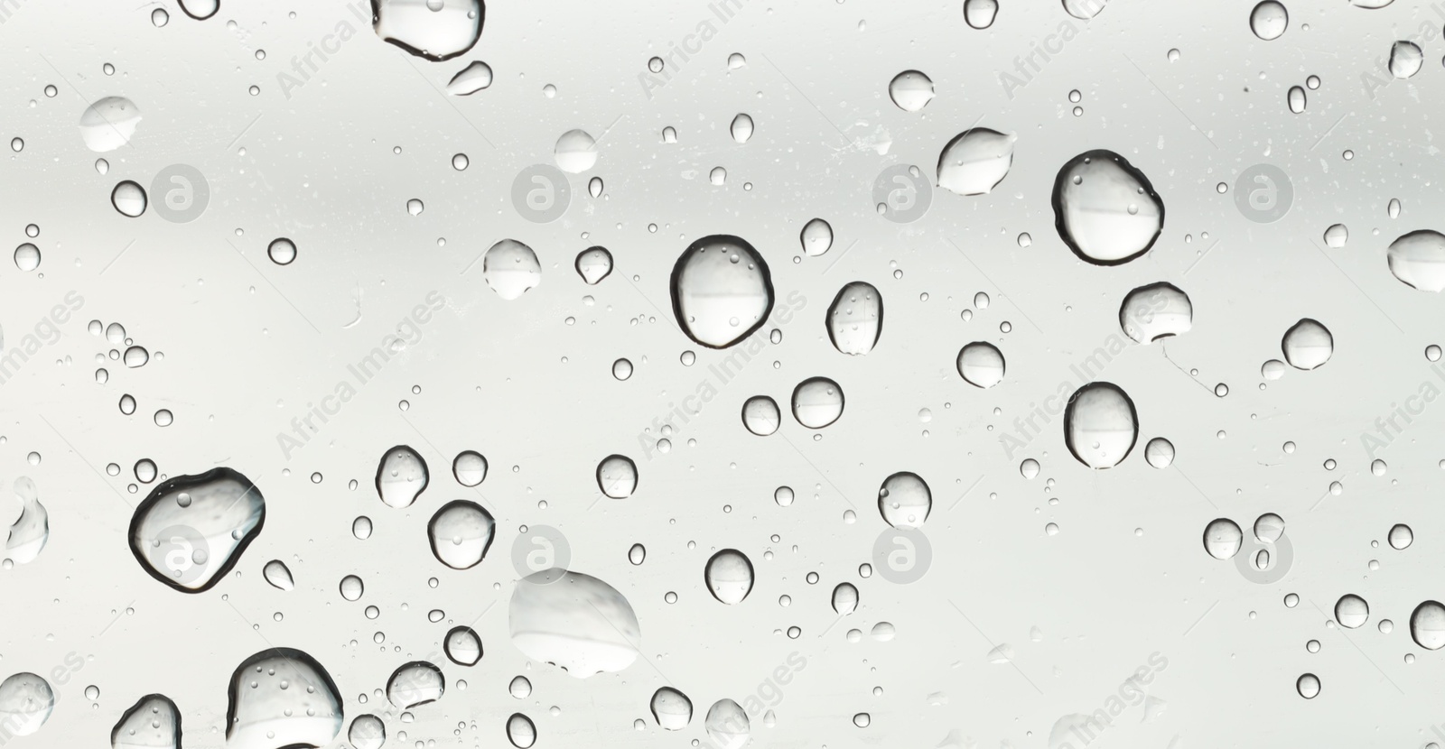 Photo of Water drops on light grey glass surface, top view