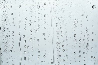 Many water drops on light glass surface, closeup