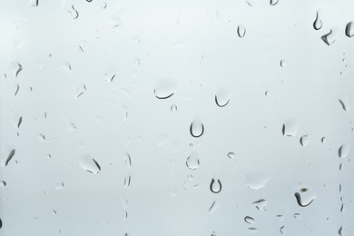 Many water drops on light glass surface, closeup