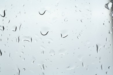 Many water drops on light glass surface, closeup