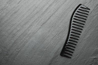 Photo of One plastic hair comb on grey background, top view. Space for text