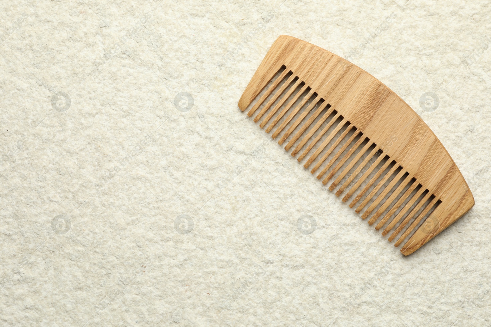 Photo of One wooden hair comb on beige background, top view. Space for text