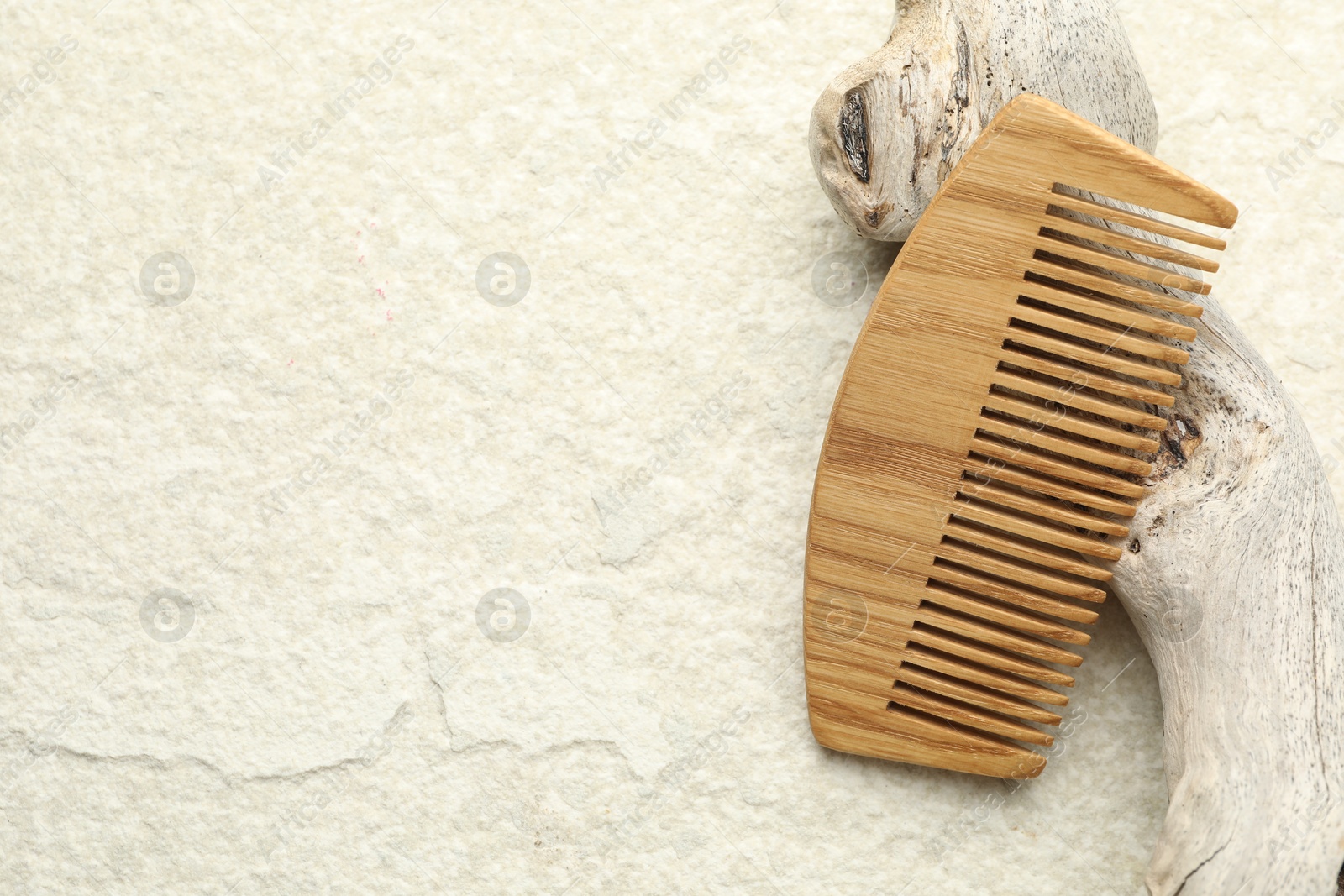 Photo of One wooden hair comb on beige background, top view. Space for text