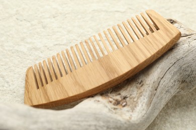 Photo of One wooden hair comb on beige background, closeup