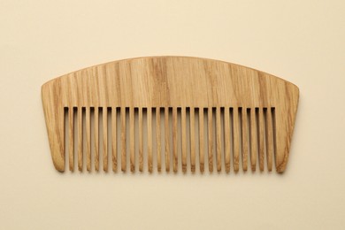 One wooden hair comb on beige background, top view