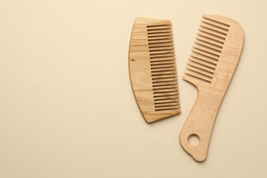 Photo of Different wooden hair combs on beige background, top view. Space for text