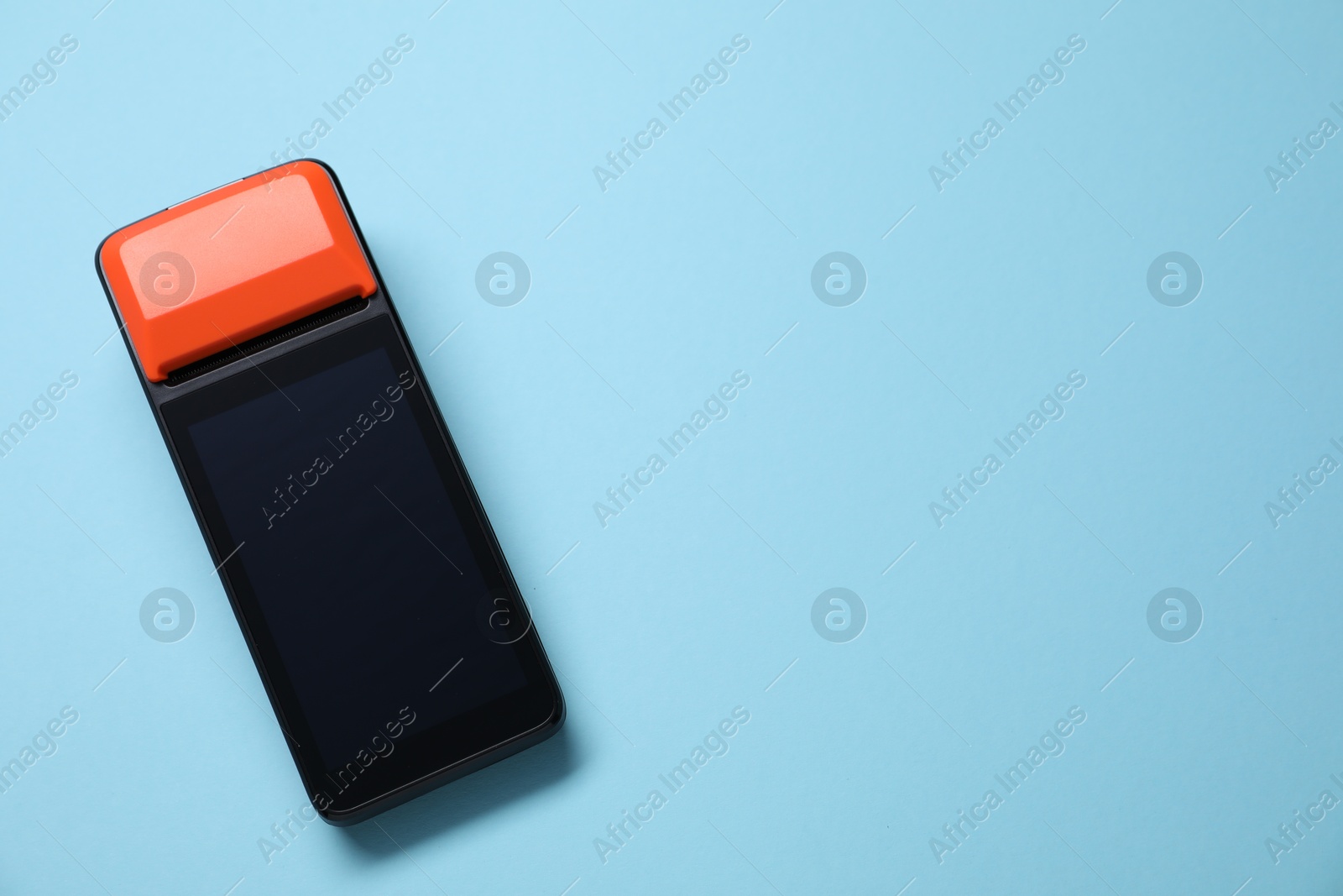 Photo of One payment terminal on light blue background, top view. Space for text