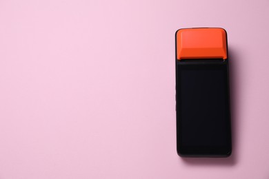 Photo of One payment terminal on pink background, top view. Space for text