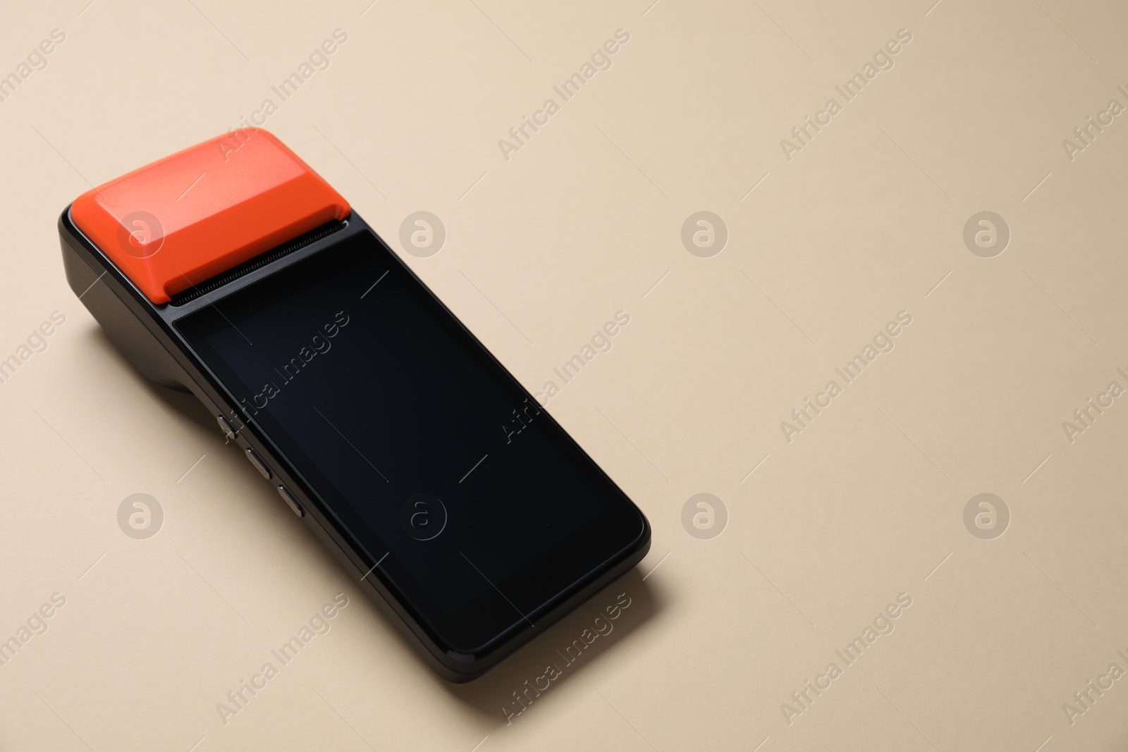 Photo of One payment terminal on beige background, closeup. Space for text