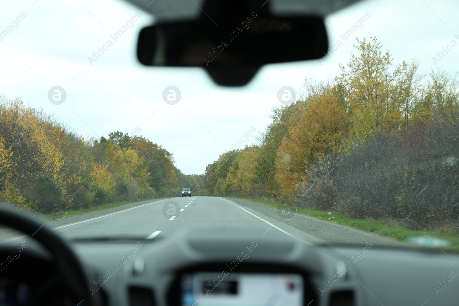 Photo of Car driving on asphalt road, view from inside through windshield