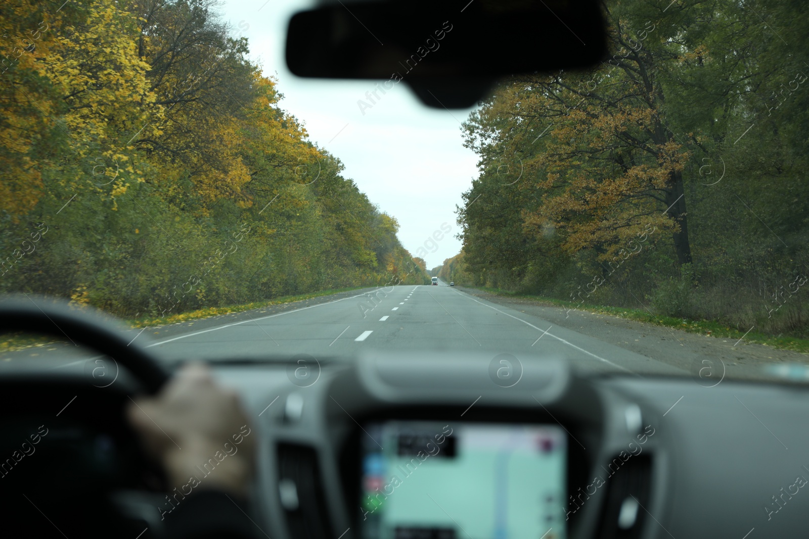 Photo of Man driving car, view on road through windshield