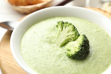 Photo of Delicious broccoli cream soup served on table, closeup