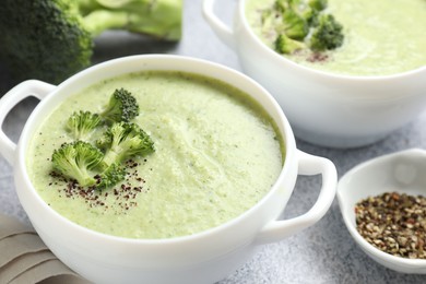 Photo of Delicious broccoli cream soup served on light table, closeup