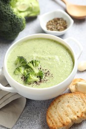 Photo of Delicious broccoli cream soup served on light table, closeup