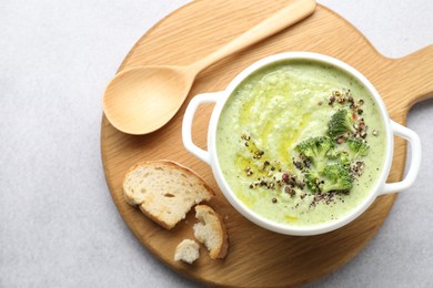 Photo of Delicious broccoli cream soup served on light table, top view