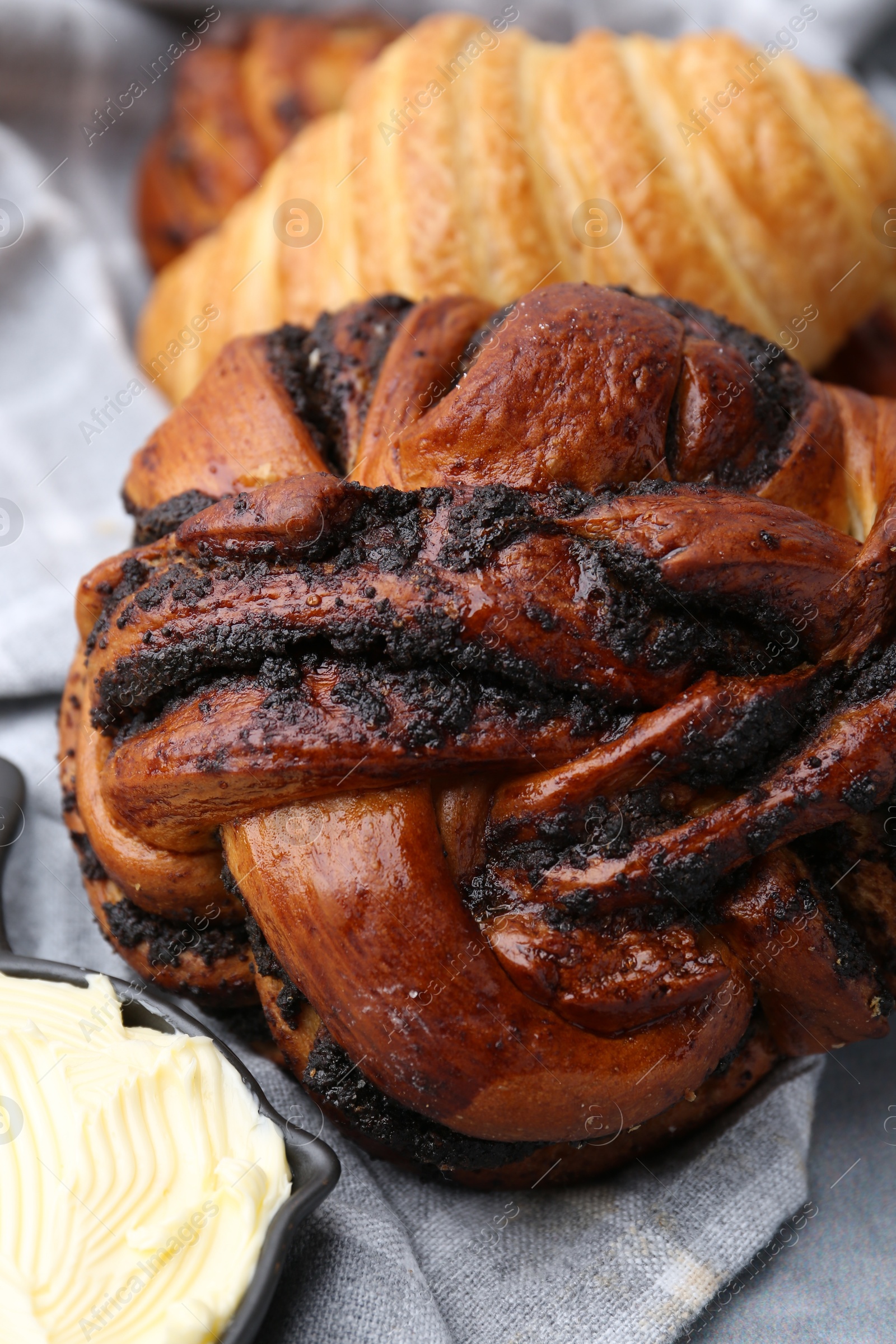 Photo of Different delicious pastries and butter on grey table, closeup