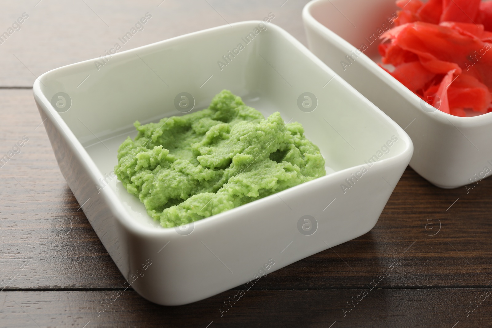 Photo of Hot wasabi paste and ginger on wooden table, closeup