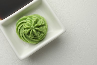 Photo of Hot wasabi paste and soy sauce on white table, top view. Space for text