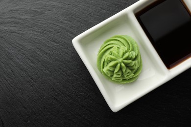 Photo of Hot wasabi paste and soy sauce on grey table, top view. Space for text