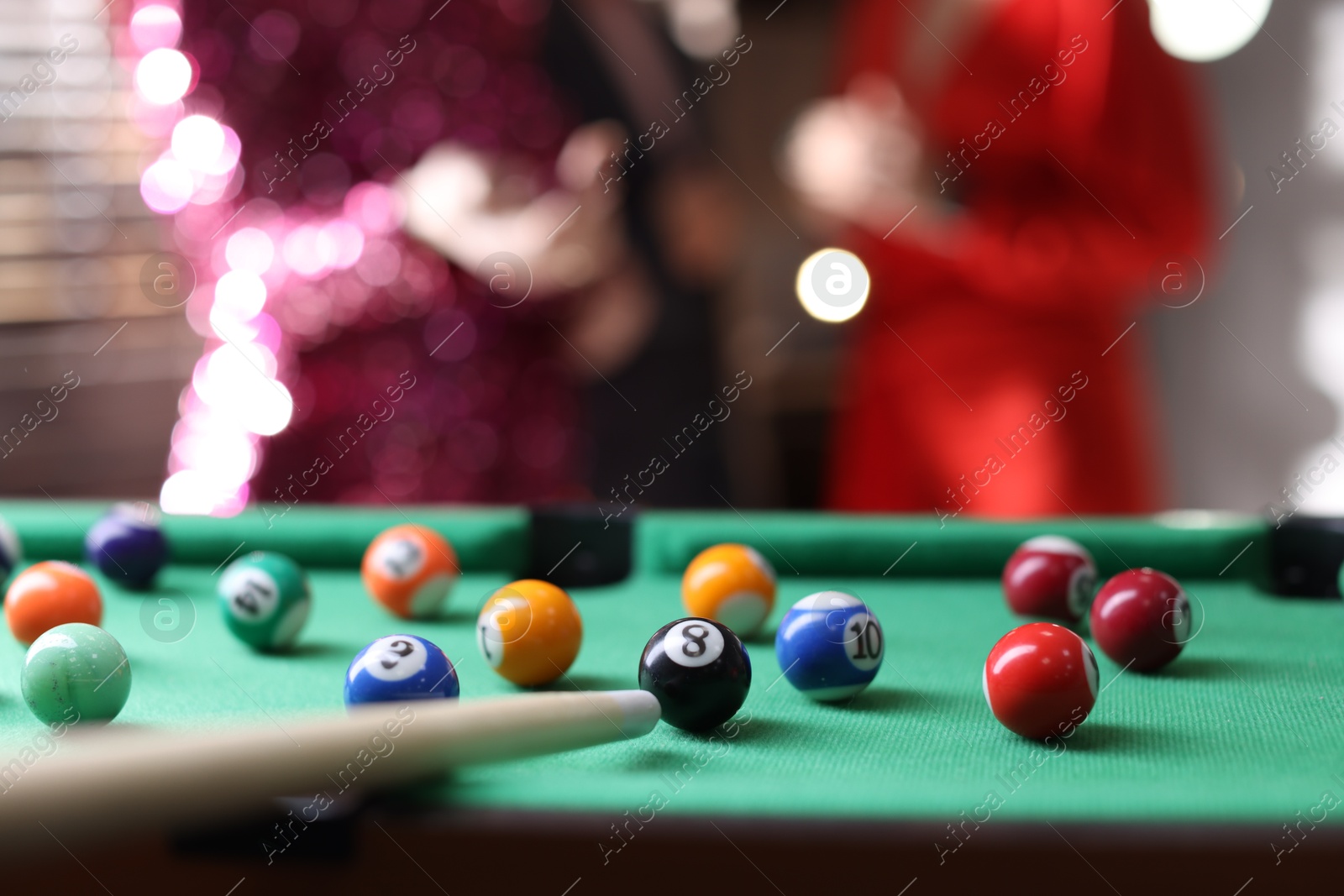 Photo of Many colorful billiard balls and cue on green table indoors, closeup. Space for text