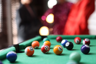 Photo of Many colorful billiard balls on green table indoors, closeup. Space for text