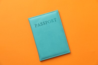 Photo of Passport in bright cover on orange background, top view