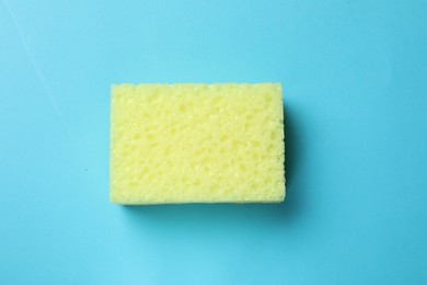 Photo of Soft sponge on light blue background, top view. Cleaning tool