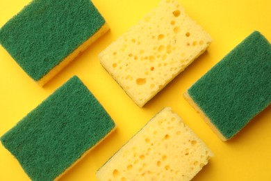 Photo of Soft sponges on yellow background, flat lay. Cleaning tool