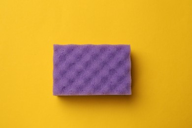 Photo of Soft sponge on orange background, top view. Cleaning tool