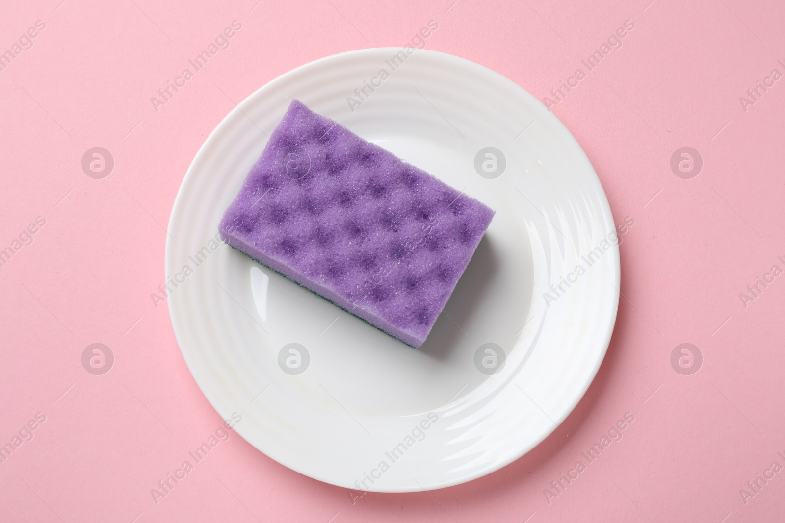 Photo of Plate with sponge on pink background, top view