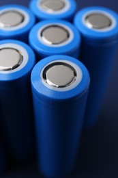 Photo of Many AA cell batteries on blue background, closeup