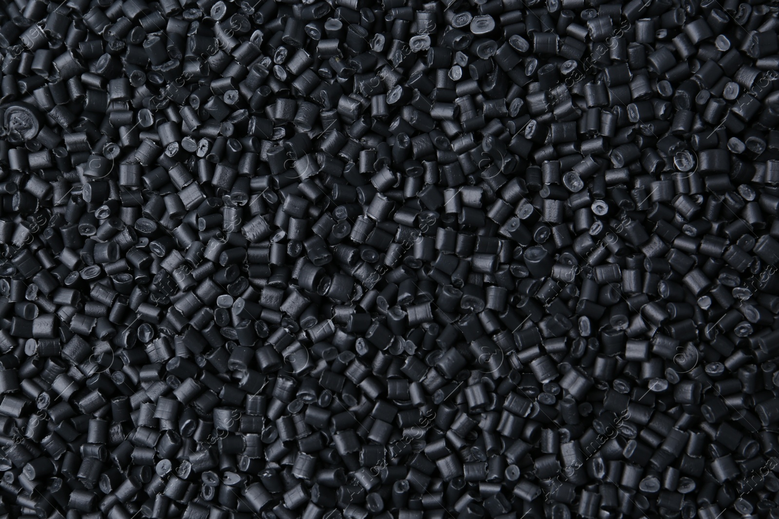 Photo of Pile of black plastic granules as background, top view