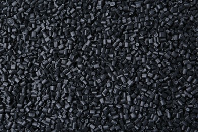 Photo of Pile of black plastic granules as background, top view