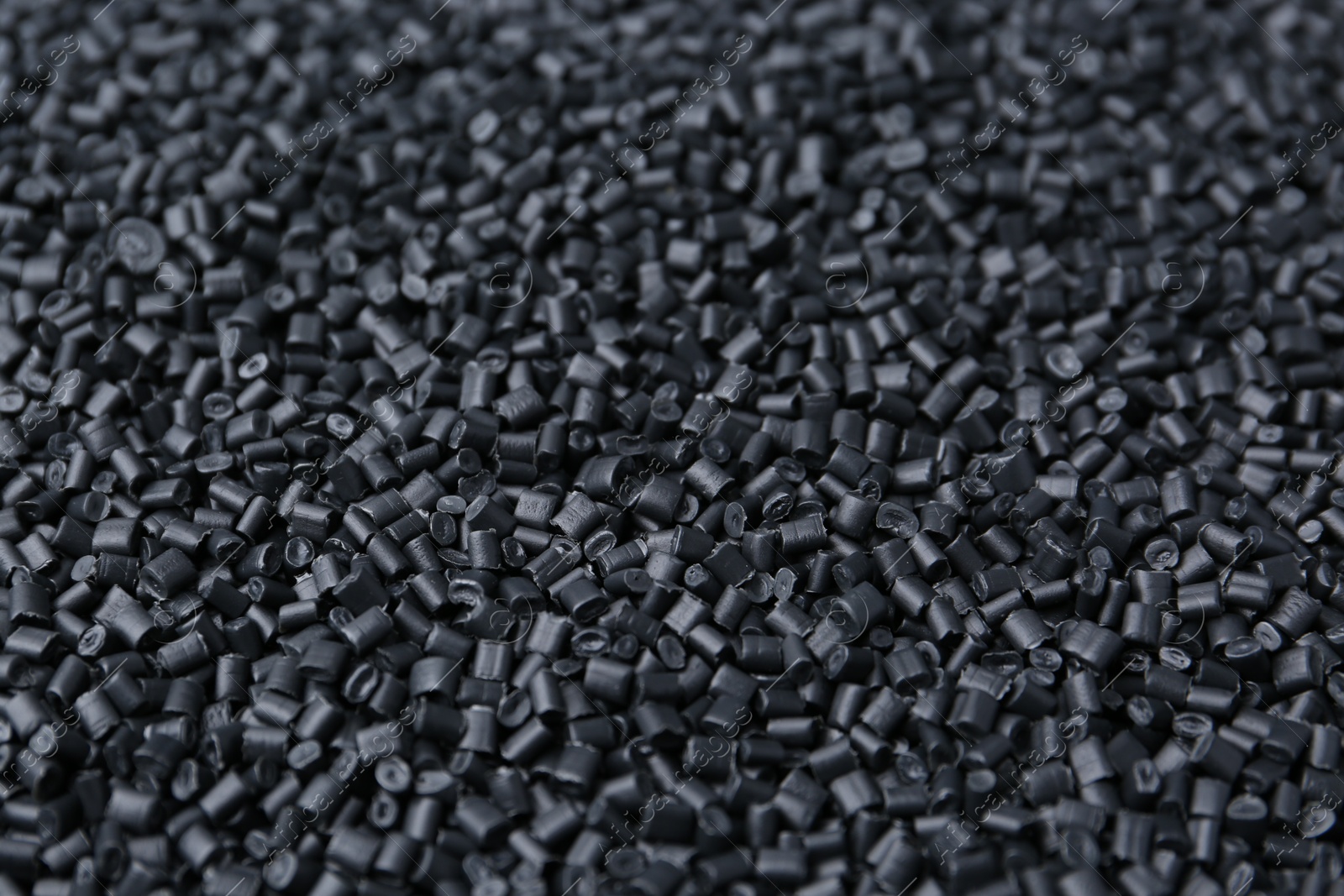 Photo of Pile of black plastic granules as background, closeup