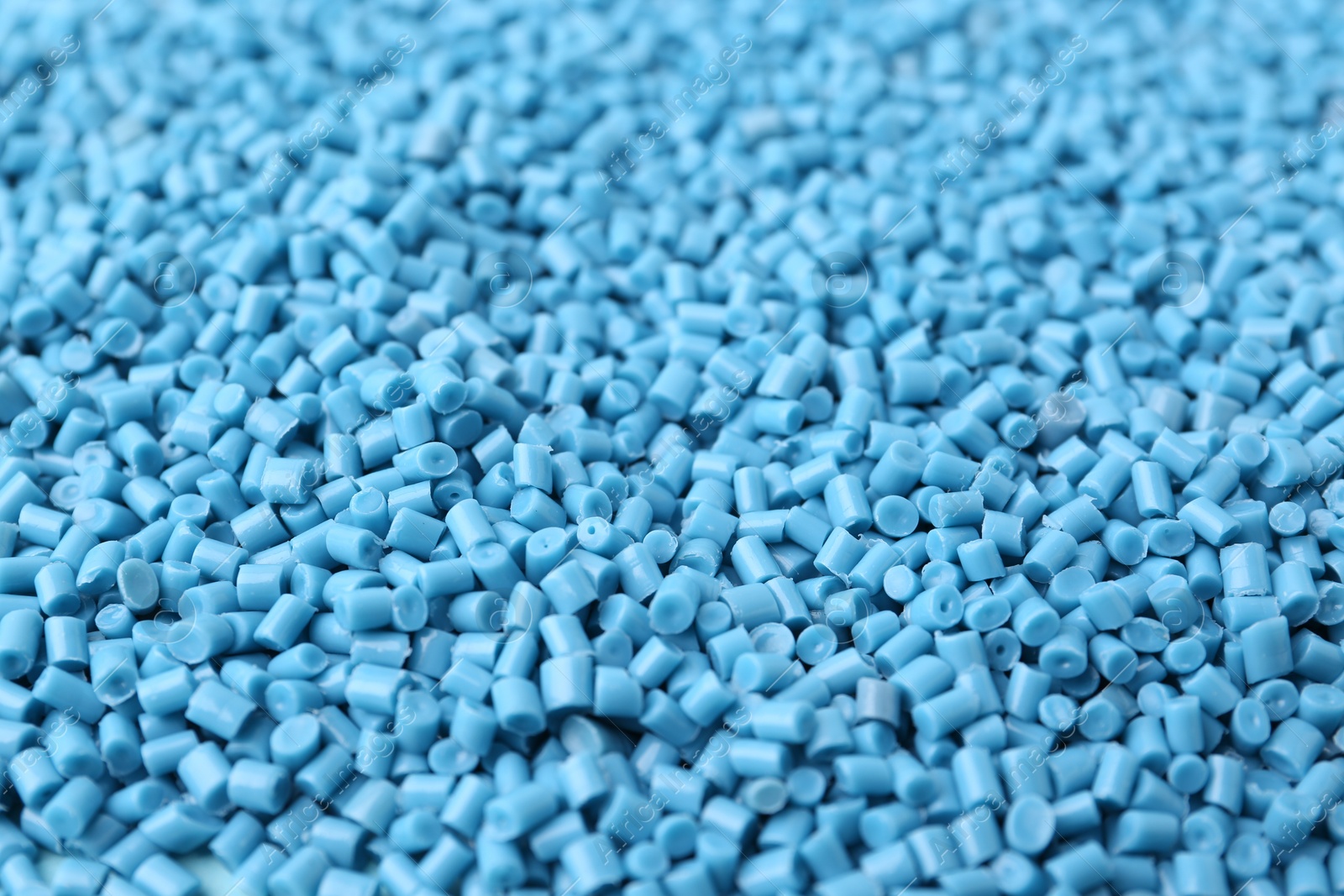 Photo of Pile of light blue plastic granules as background, closeup