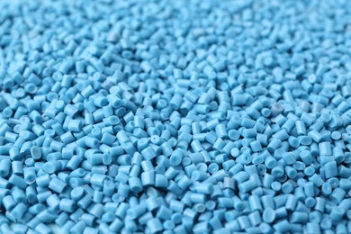 Pile of light blue plastic granules as background, closeup