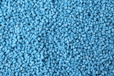 Photo of Pile of light blue plastic granules as background, top view