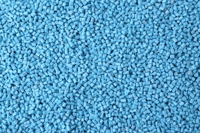 Pile of light blue plastic granules as background, top view