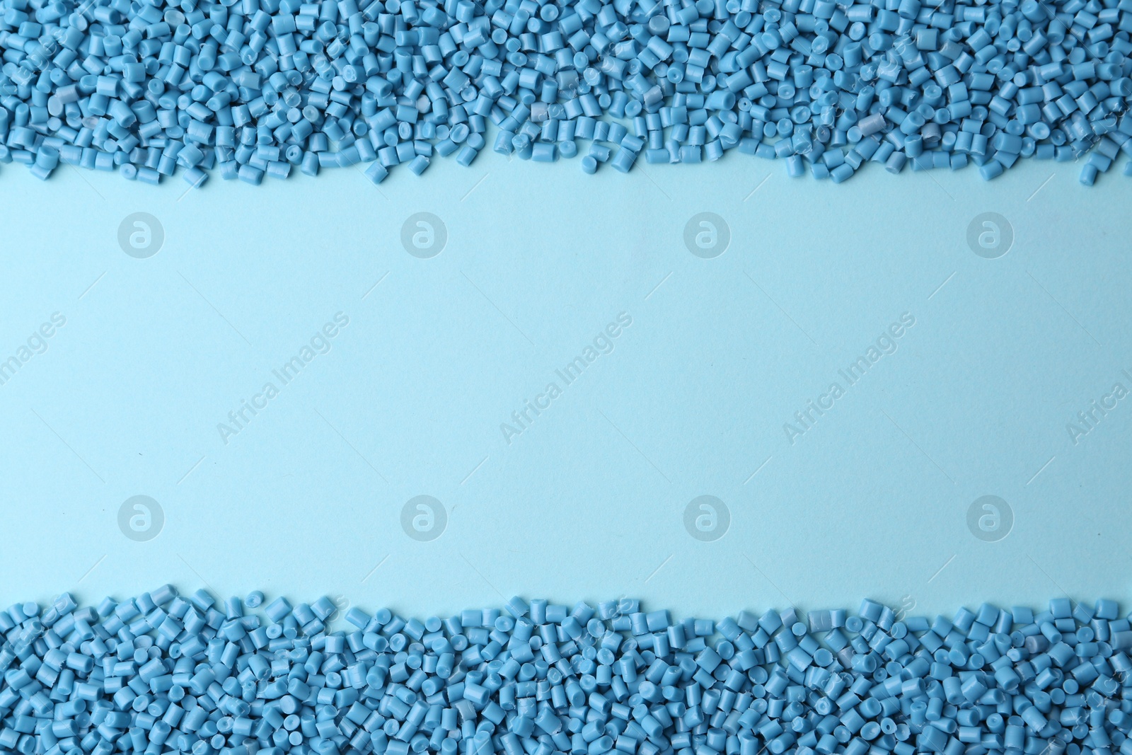 Photo of Pile of plastic granules on light blue background, top view. Space for text