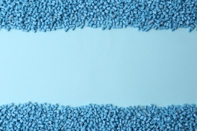 Photo of Pile of plastic granules on light blue background, top view. Space for text